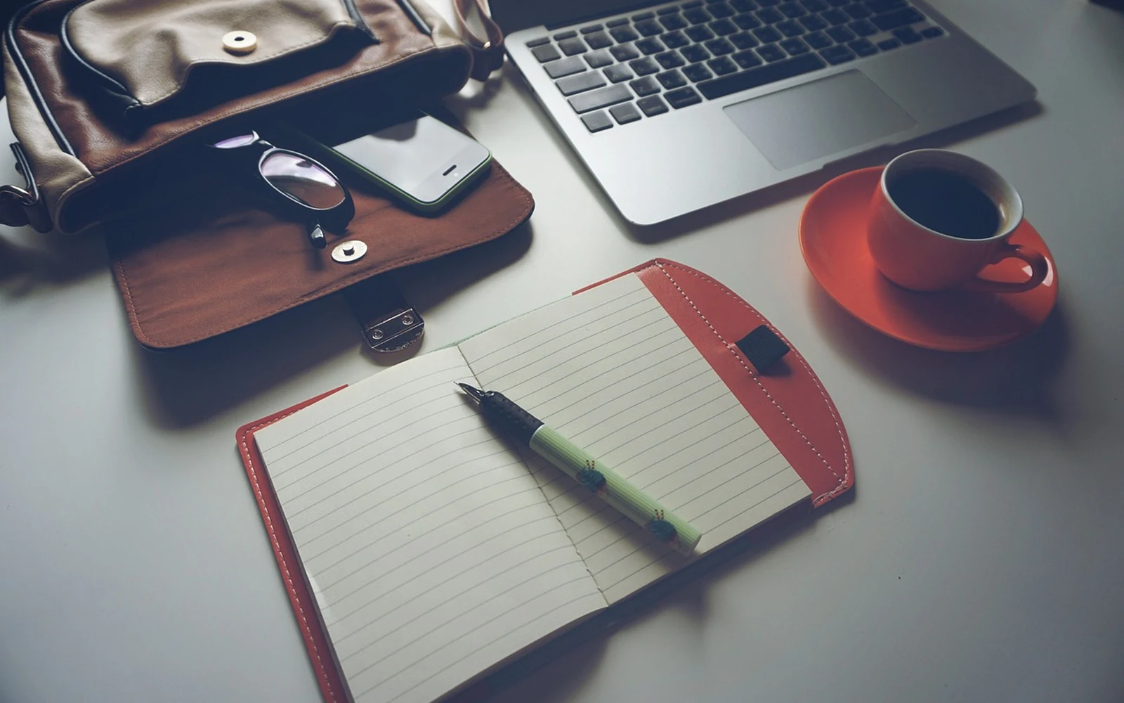 Table de travail de la rédaction : carnet, ordinateur, café