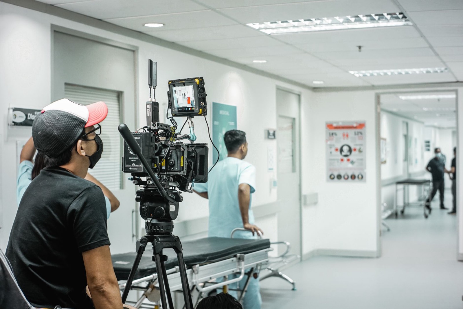 Équipe et matériel de tournage installés sur un plateau de film pendant une attente entre deux prises