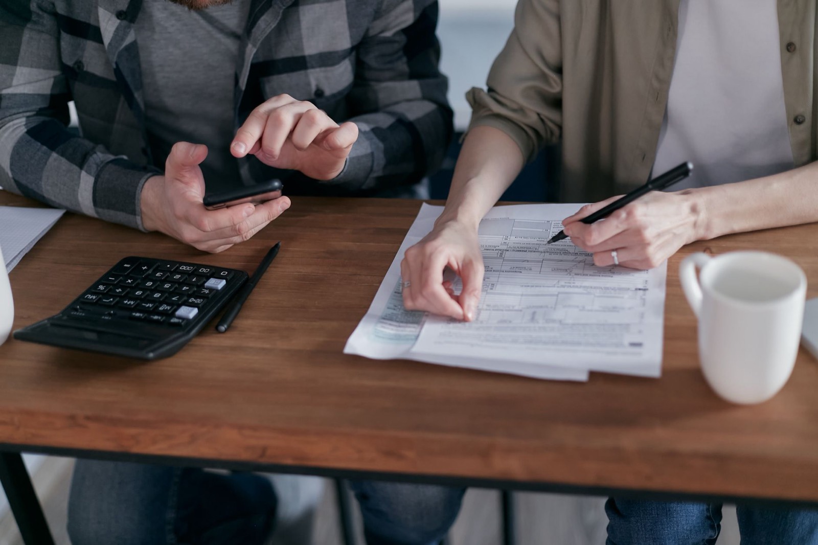 Documents financiers, calculatrice et stylo posés sur un bureau avant un rendez-vous patrimonial