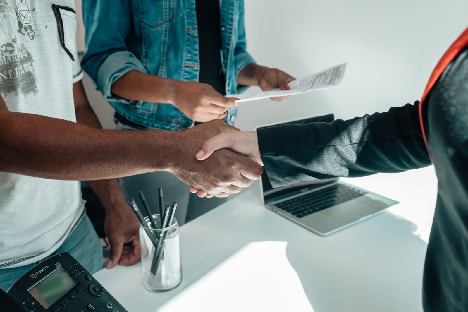 Poignée de main au-dessus d'un bureau à la fin d'un premier rendez-vous avec un conseiller