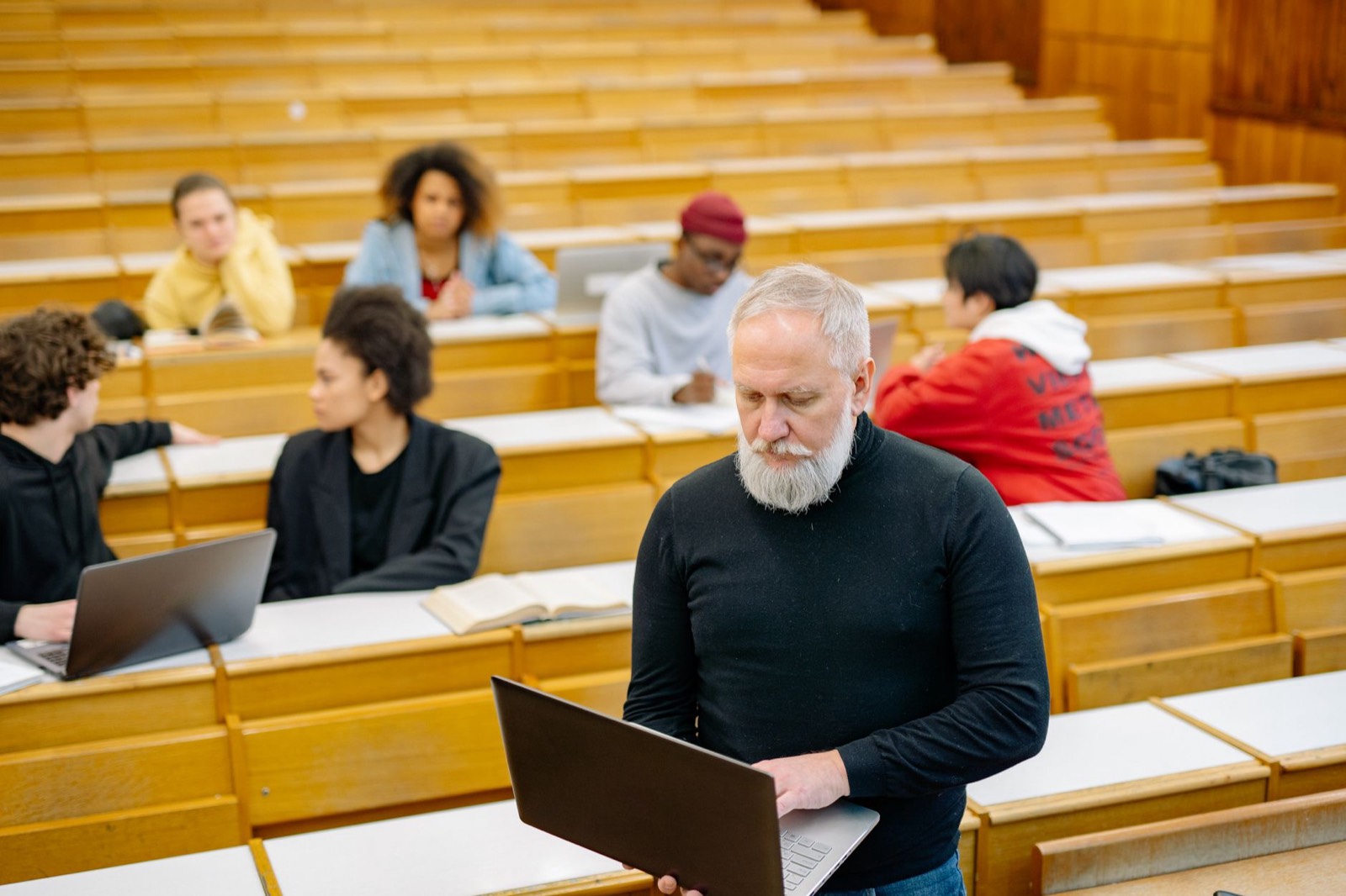 Étudiants en amphithéâtre suivant un cours avec des ordinateurs portables
