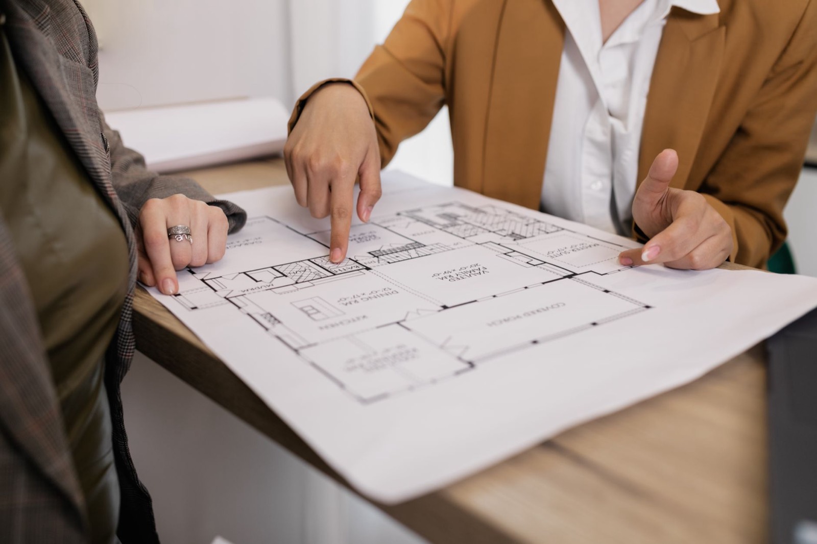 Un couple examine les plans de sa future maison étalés sur une table